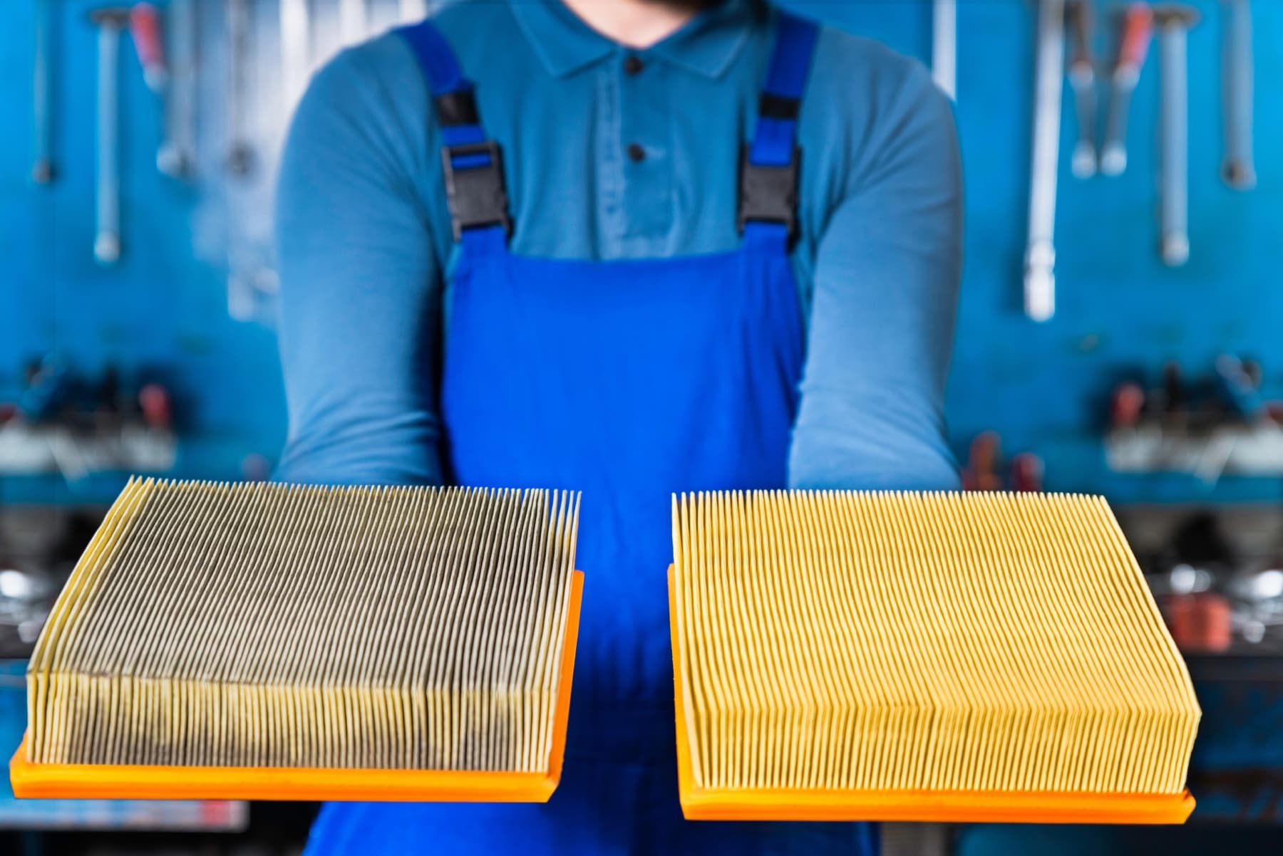 Technician holding a dirty and clean industrial pleated filter side by side for route exchange