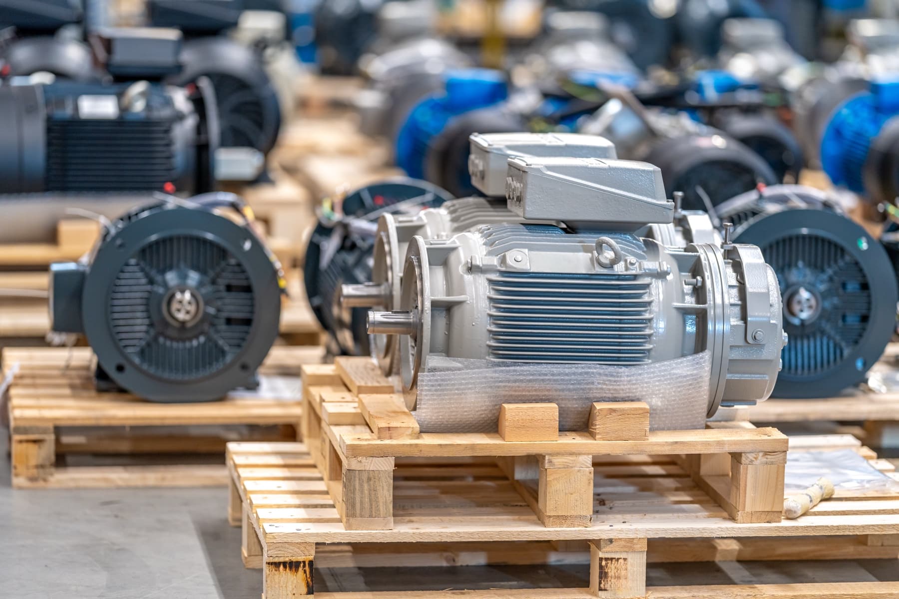Industrial electric motors staged on pallets in a motor service shop